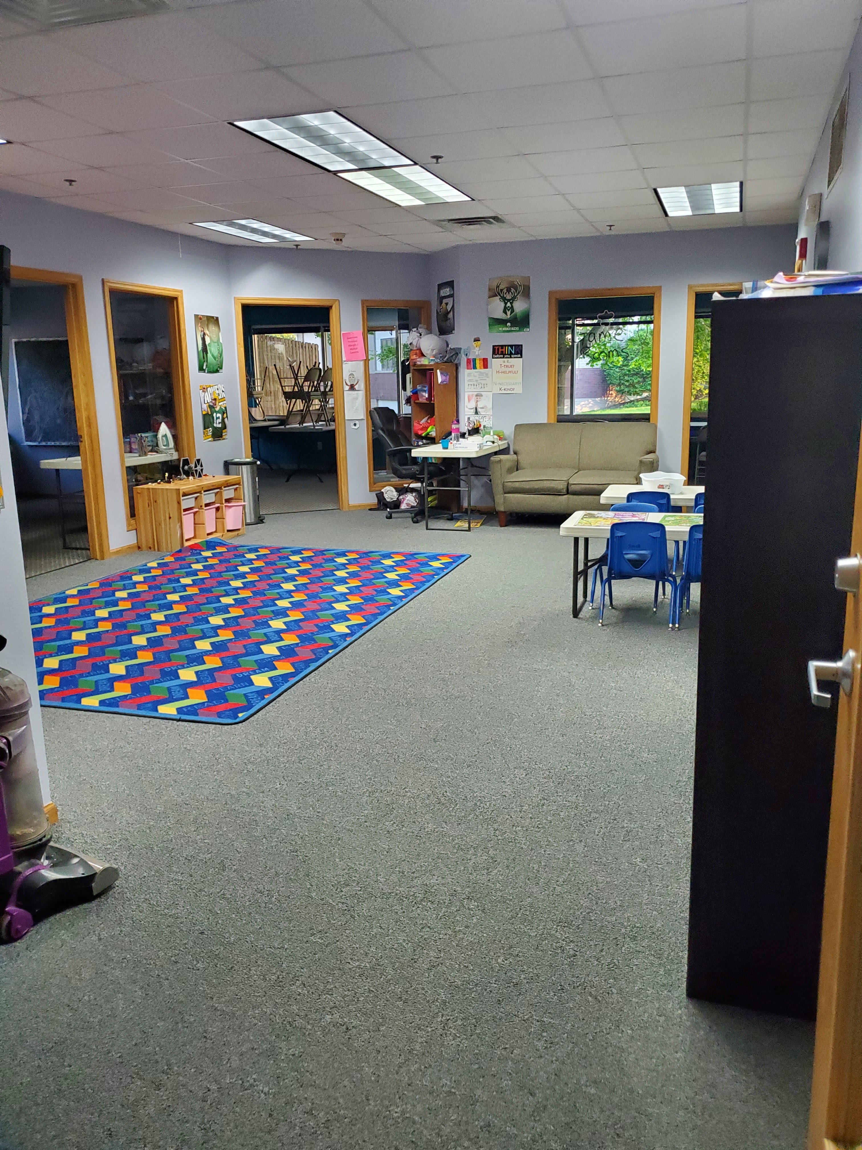 Spacious room with colorful rug and seating areas